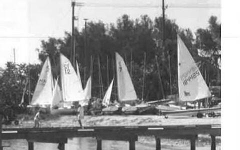 A row of Albacore dinghies rigged at the dock in Sarasota