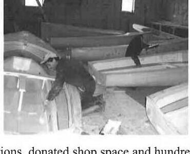 A volunteer working among a stack of Albacore hulls in the boat shop
