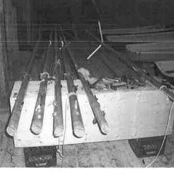 Centreboards and spars laid across a trestle in the boat shop