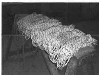 A coil of line resting on a sawhorse in the boat shop