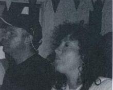 A man and woman at an indoor party, with bunting hanging in the background
