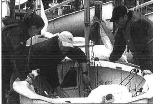 A group working on the deck and mast of an Albacore during spring maintenance