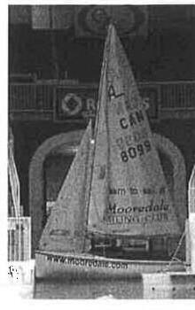 An Albacore rigged indoors at the Toronto International Boat Show, sail number 8099