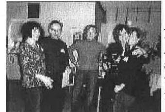 A group of five attendees posing together at the party