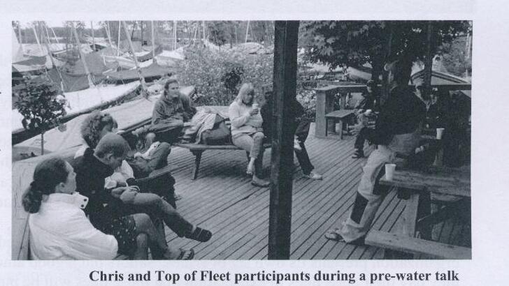Chris and Top of Fleet participants during a pre-water talk on a clubhouse deck