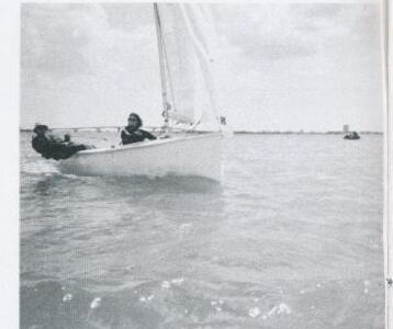 A black and white photo of an Albacore sailing with two crew aboard