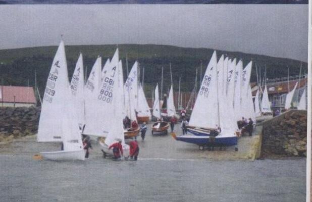 A fleet of Albacores launching from a stone slipway in Largs, Scotland, under a grey sky
