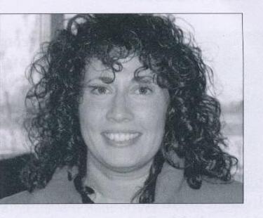 Portrait of Cathyann White, smiling, with curly dark hair