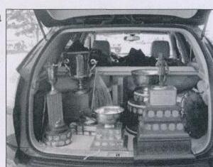 A car's open trunk packed full of sailing trophies