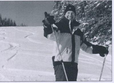A person cross-country skiing on a snowy slope, arms raised with ski poles