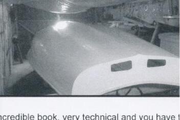 An Albacore hull with its first few white top-coats of paint applied, in a workshop