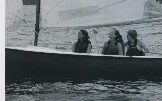 Three cousins looking up at the sail while sailing Miss Genevieve, a rescued Allen Albacore
