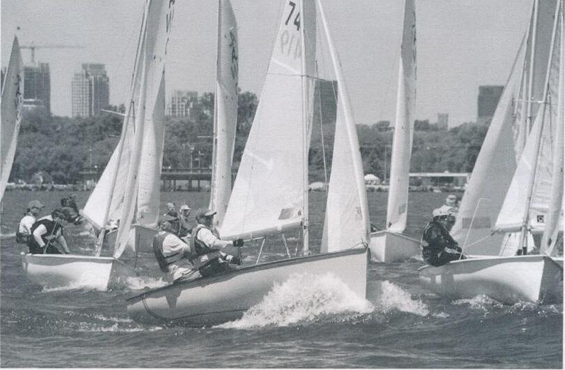 A fleet of Albacores sailing hard with the Toronto skyline in the background