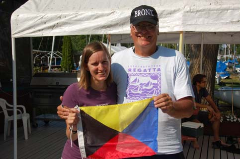 Peter Vasoff and a young woman holding a signal flag under a tent at a regatta