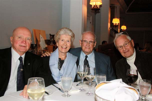 Paul and Mary Henderson, John Tinker and Bob Shaw seated together at a dinner table with wine glasses