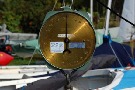 A close-up of a brass hanging scale used for boat weighing