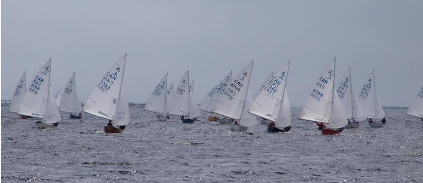 A wide Albacore fleet sailing off Shelburne Harbour under grey skies