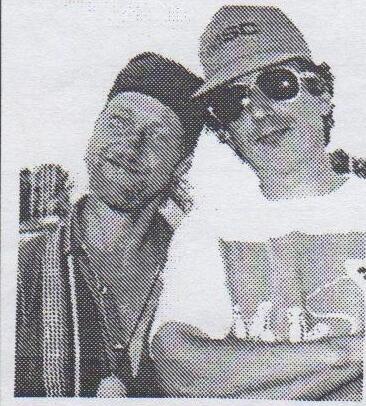 Barry and John, two smiling sailors in caps and sunglasses, leaning together