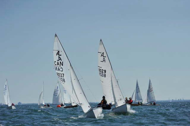 Two Albacores close together at a starting line, crews hiking hard