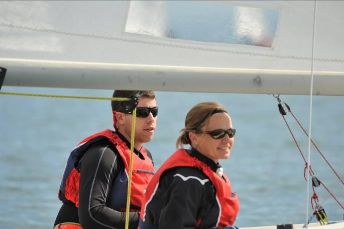 Jefferson and Tracy Hall standing under the boom of their Albacore on the water