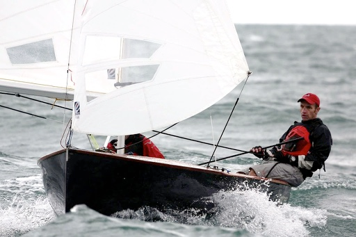 A sailor hiking hard on a black-hulled Albacore