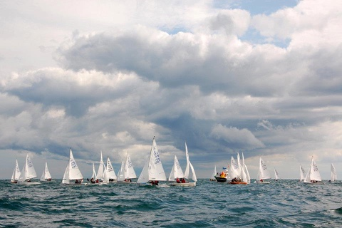 Albacore fleet racing under a dramatic cloudy sky