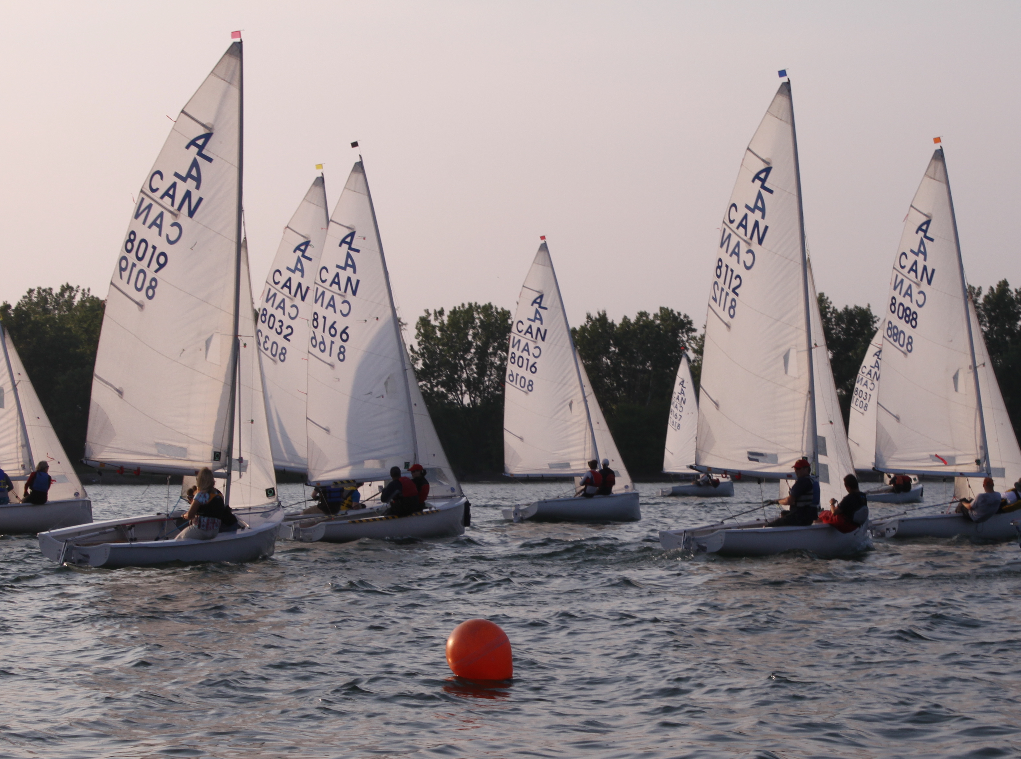 Evening Albacore fleet racing past an orange mark