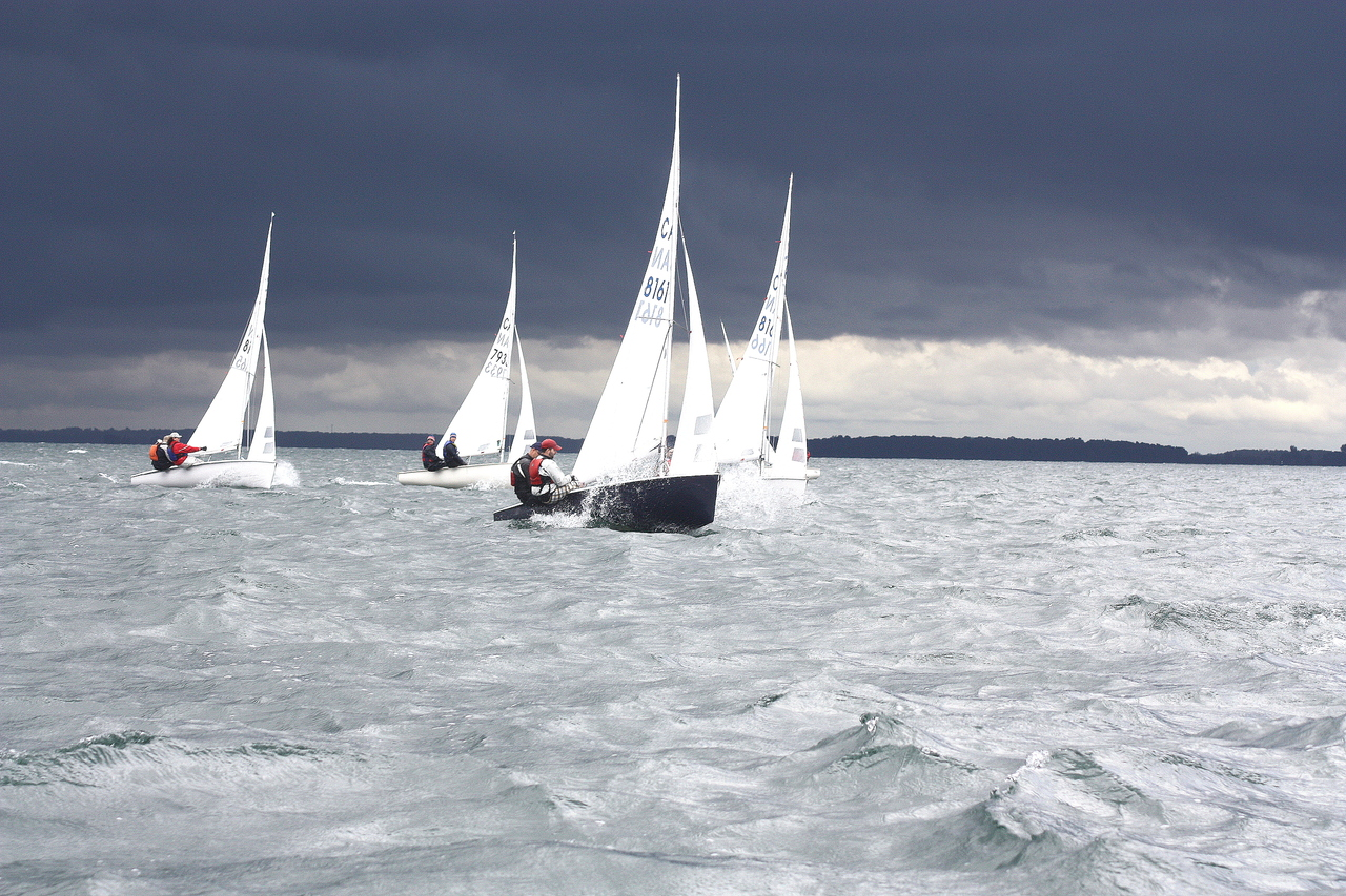 Albacore fleet racing under a dark storm front