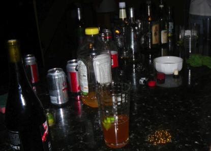 A bar counter crowded with bottles and mixed drinks