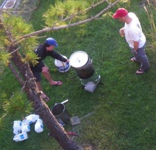 Two men aerial view deep-frying a turkey in a backyard
