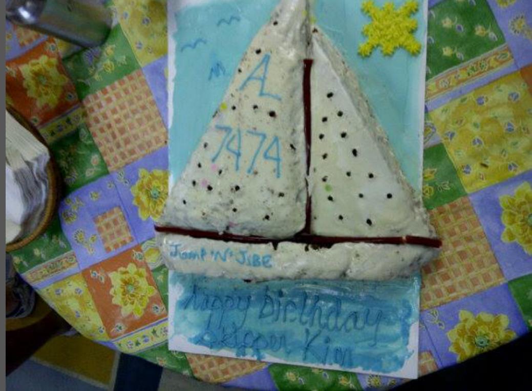 A homemade cake shaped like an Albacore sail number 7474, iced with "Happy Birthday Skipper Kim"