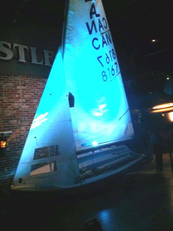 An Albacore sail lit blue, on display indoors at the Steam Whistle Brewery