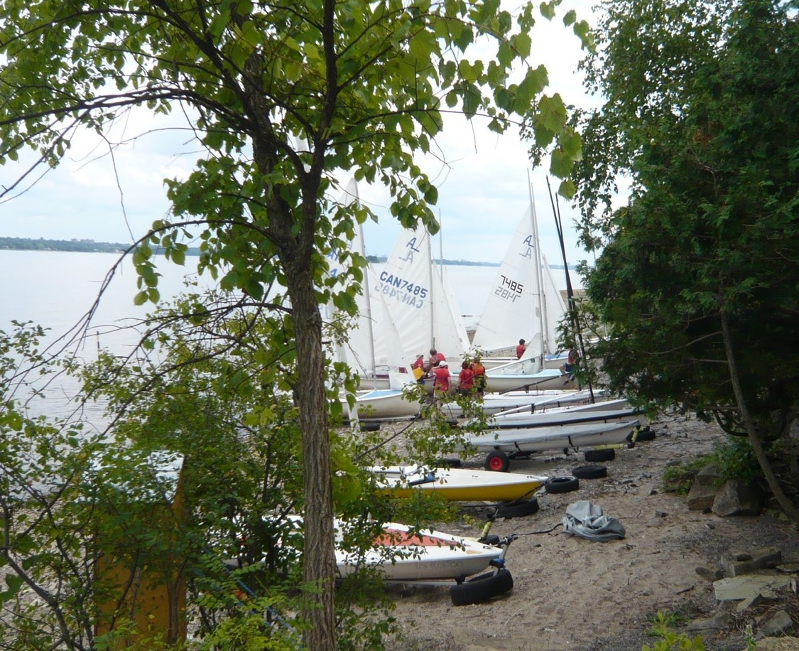 Albacores pulled up on a wooded beach launch, sails up