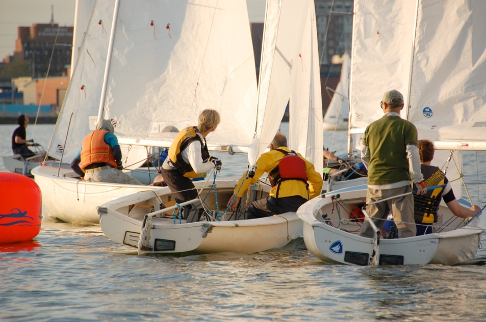Sailors rigging Albacores at the dock in low evening light
