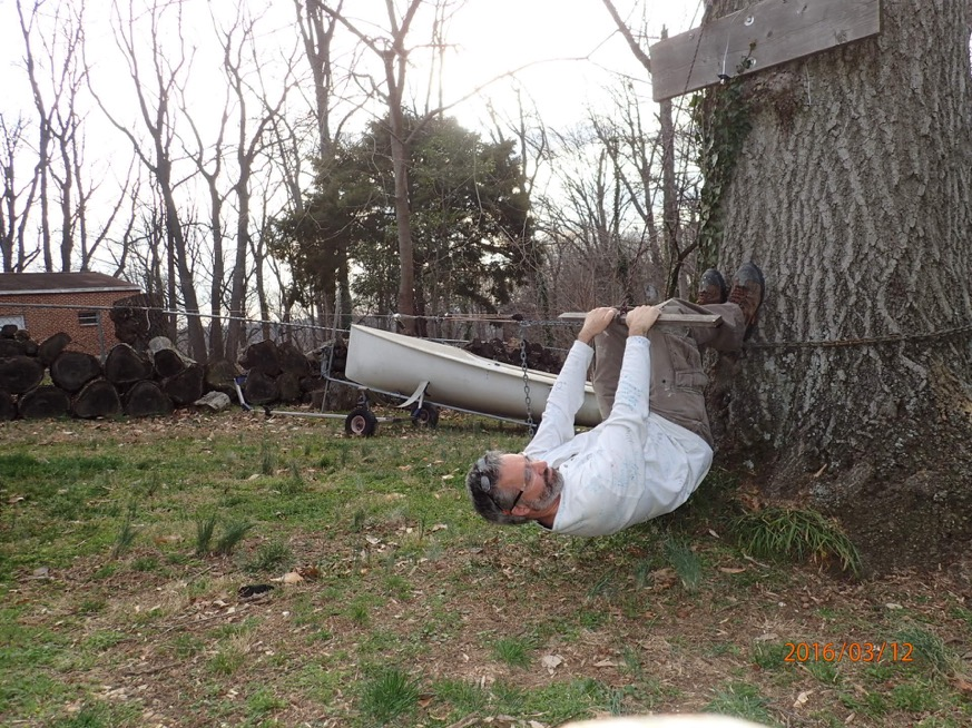 Figure 4: Barney Harris hanging upside-down from a tree branch in a homemade shroud tensile proof test rig