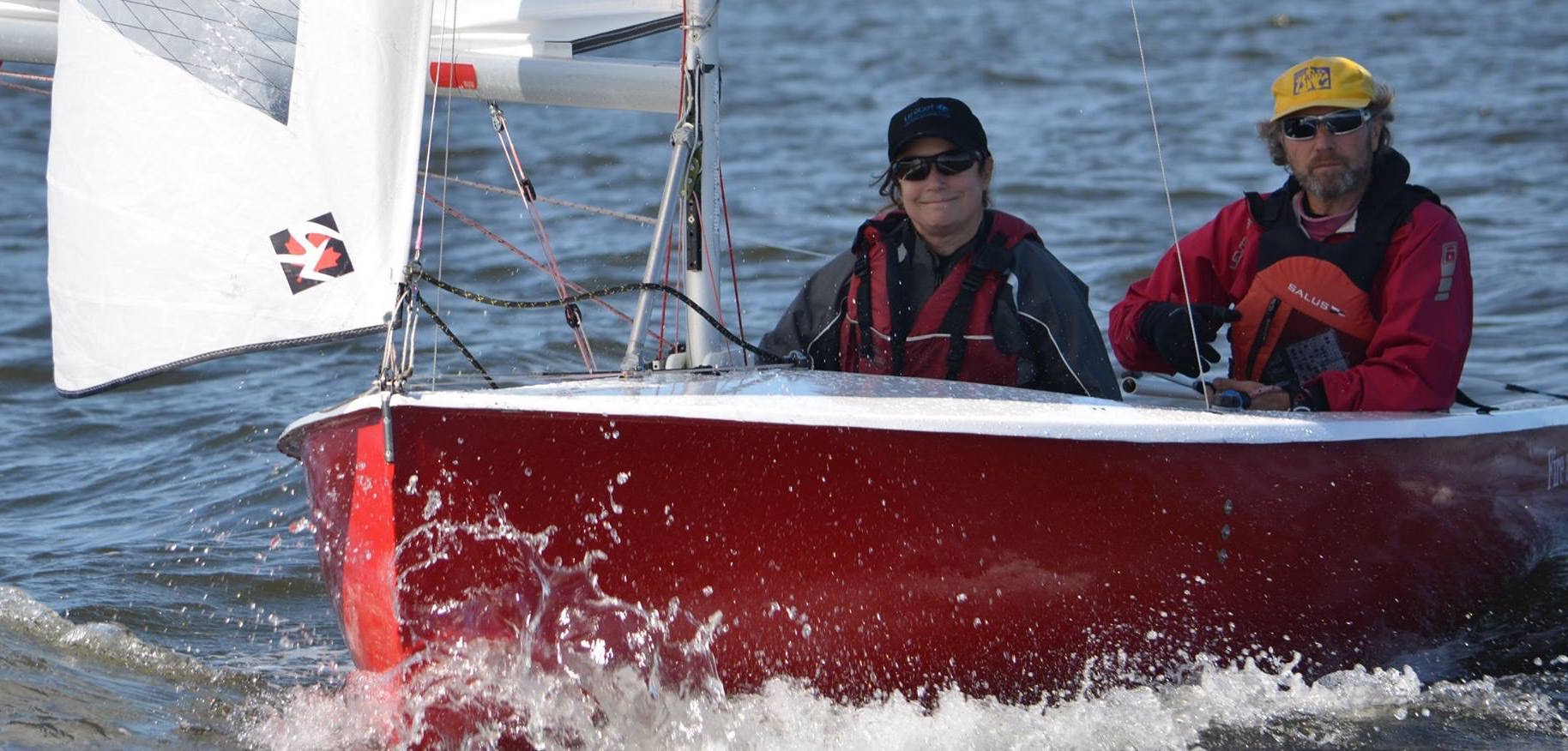 A red Albacore heeling hard, splashing through waves