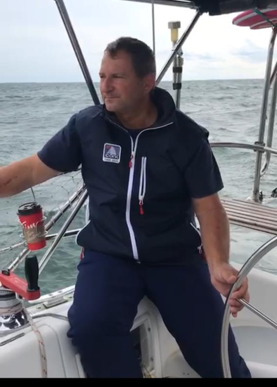 Adam Kubik at the helm of a boat
