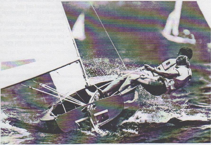 Black-and-white photo of an Albacore planing hard through spray, both sailors hiked out