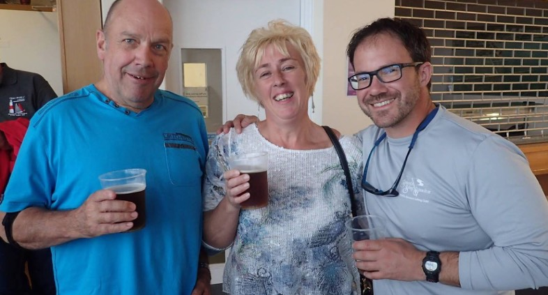 Judy Armstrong, Paul, and a friend celebrating with drinks