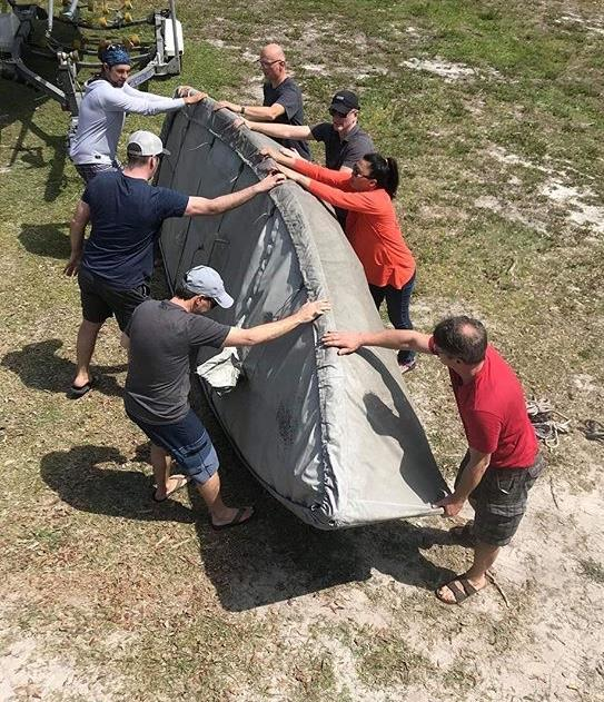 A team of sailors flipping an Albacore hull for trailering