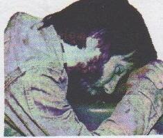 Photo of a man with his head down on his arms in despair