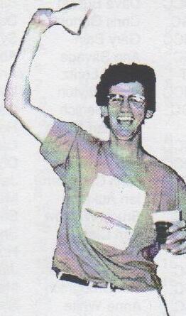 James O’Driscoll grinning, waving one arm in the air and holding a drink