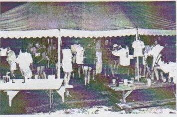 Sailors dancing under a large party tent at night