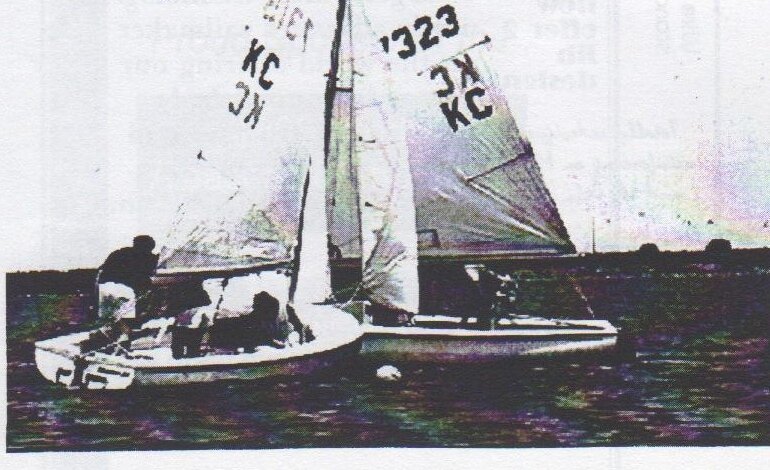Two Albacores, KC 1323 and another KC boat, overlapped and touching as they round a mark buoy