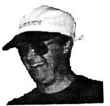 Commodore Bob Stiff in a white cap and sunglasses, smiling
