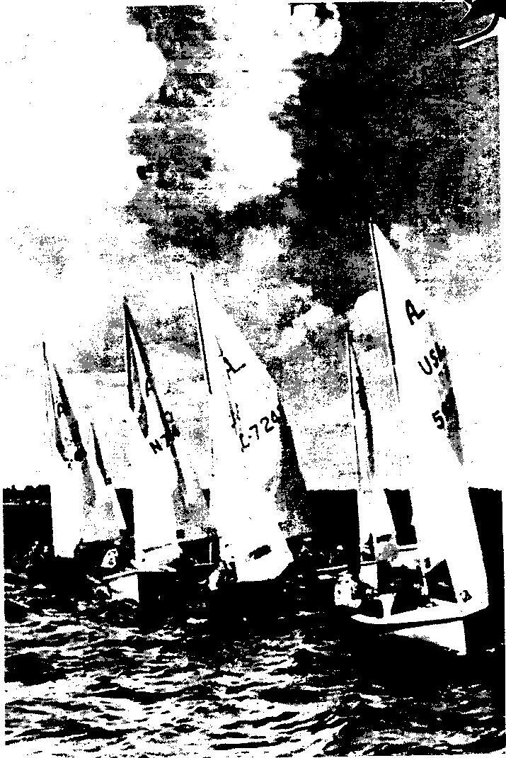 High-contrast black-and-white photo of a fleet of Albacores sailing close together under a dark, cloudy sky