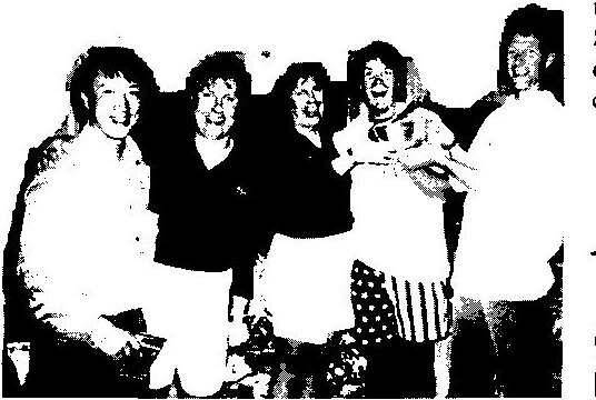 Five smiling sailors posing together with their prizes at the awards party