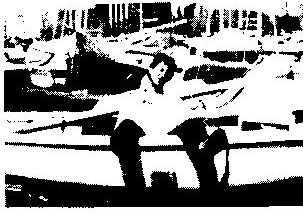 A sailor lying stretched out asleep on the deck of a boat