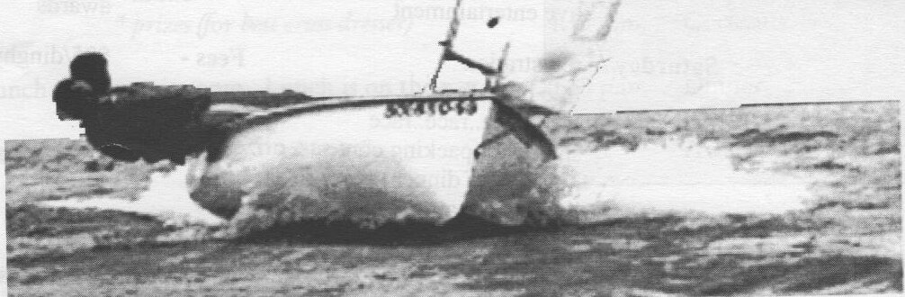 An Albacore heeled over and capsizing in a breeze, its crew sliding off the gunwale