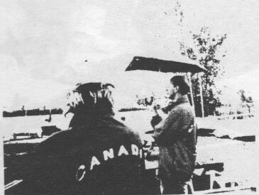 Tim Broughton, in a Canada jacket, and Steve Goode posing at a picnic table